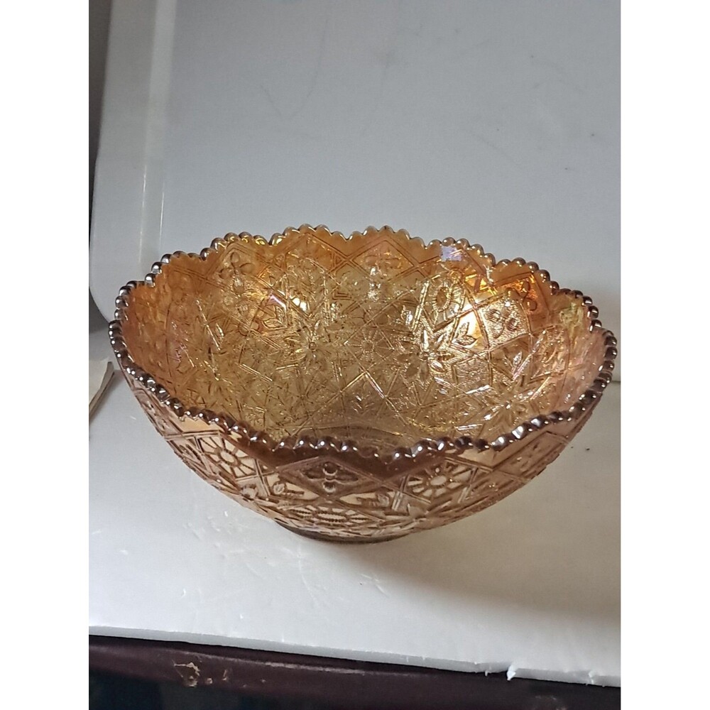 This is a vintage marigold carnival glass bowl in the "Hattie" pattern,...